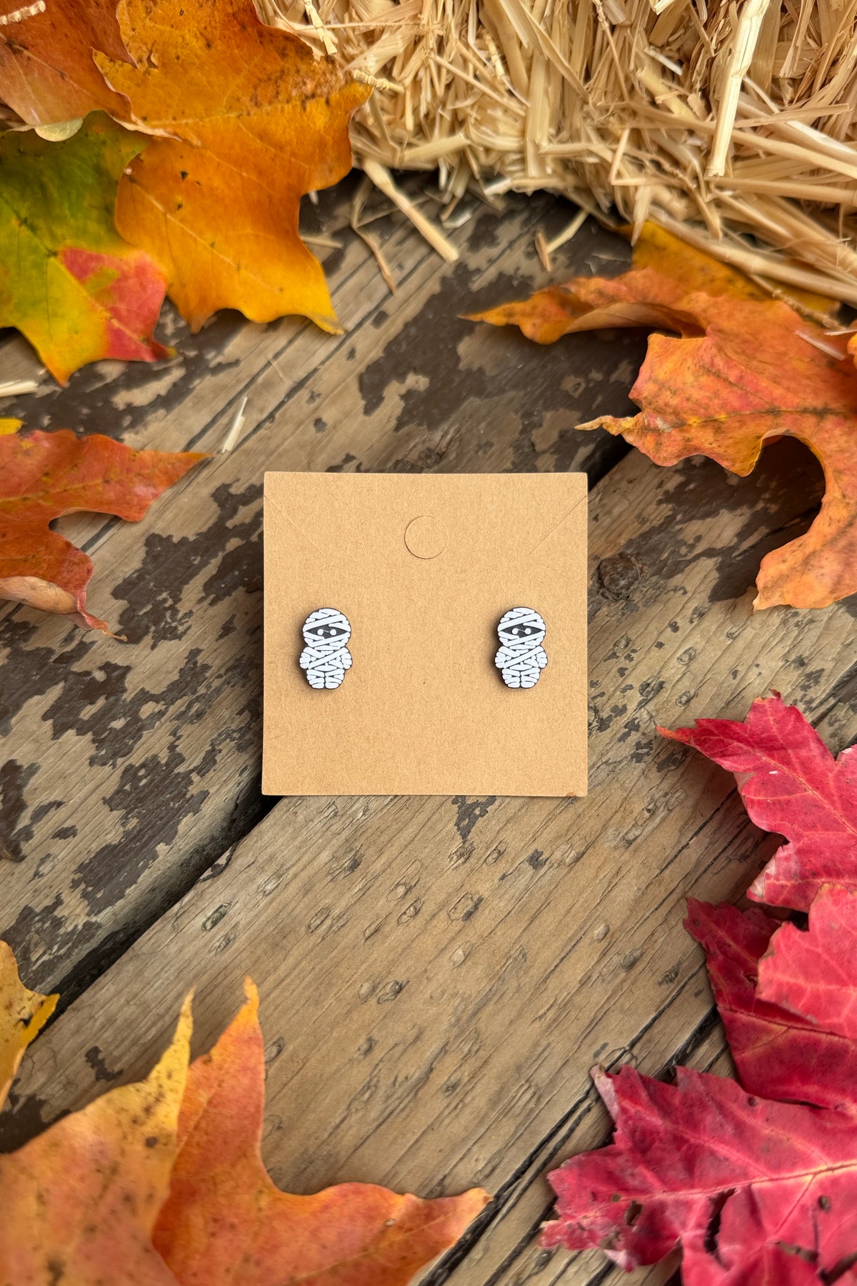 Mummy Halloween stud earrings styled with fall leaves