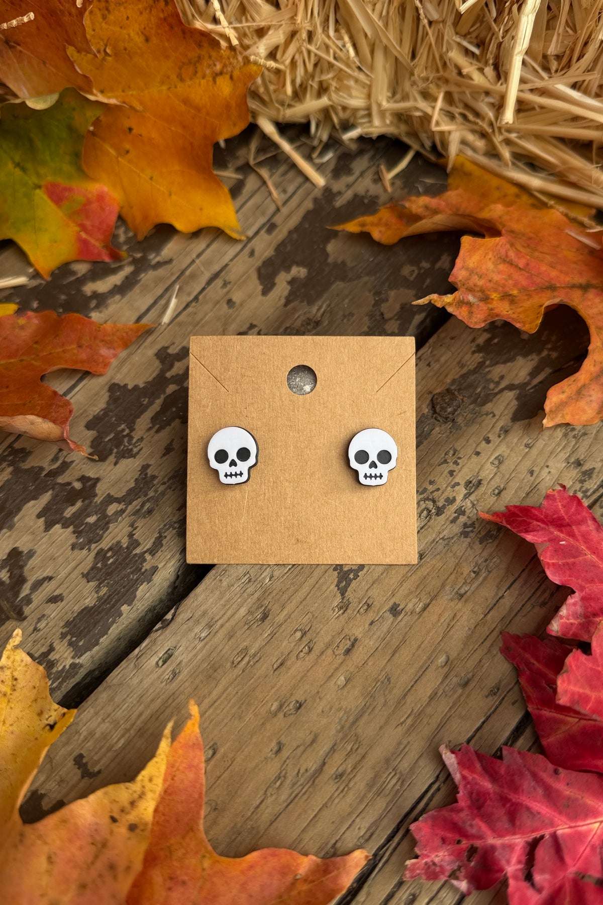 Skull Halloween stud earrings styled with fall leaves