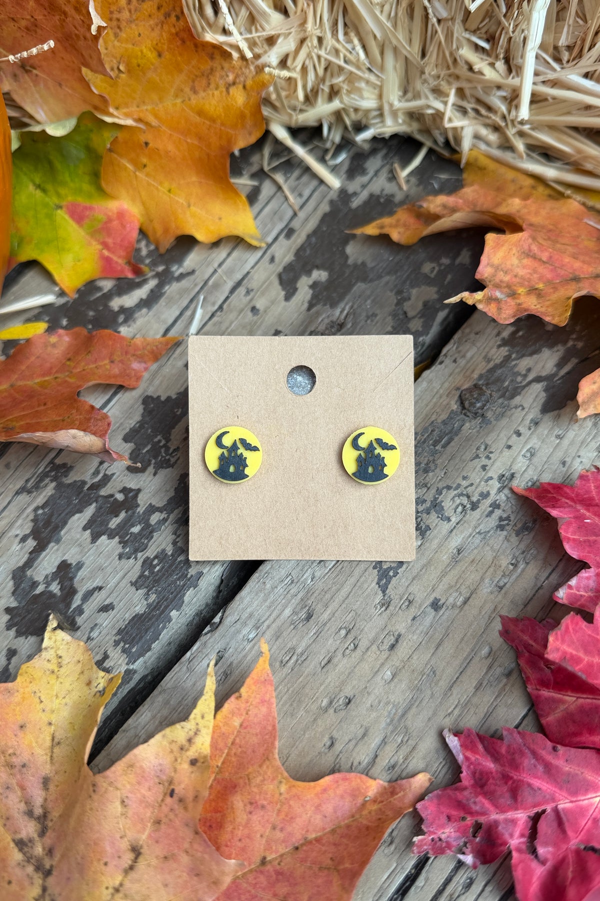 Haunted house Halloween stud earrings styled with fall leaves