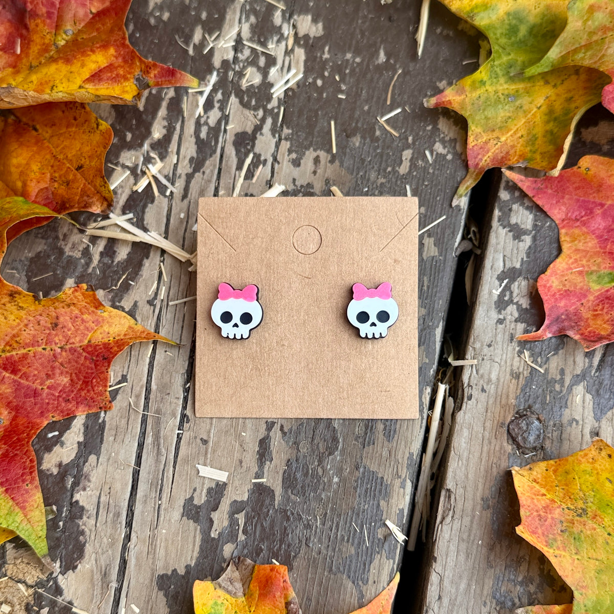 Pink Bow Skull Stud Earrings on kraft earring card